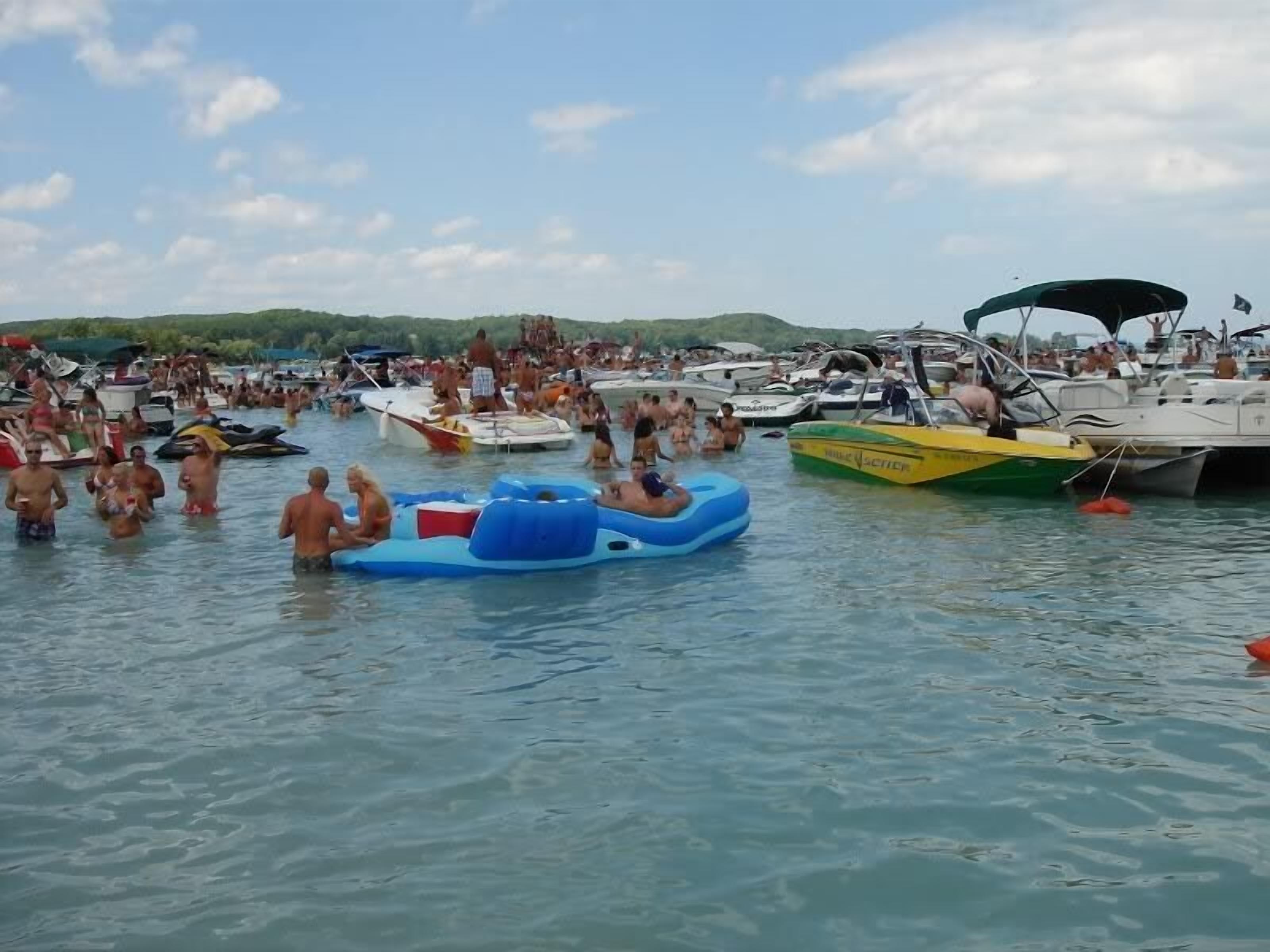 A crowded marina with numerous boats and people enjoying the water.