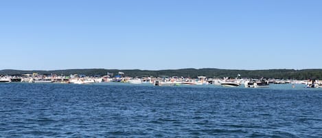 Un puerto deportivo con numerosas embarcaciones amarradas, rodeado por un paisaje montañoso.