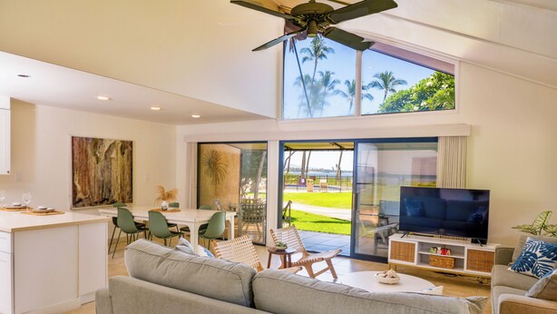 A modern living room with a sofa, TV, and dining area. - Ma'alaea Surf Unit C1 Beachfront Condo, 2BR Ground Floor, AC, Wifi, Kitchen (Kihei)