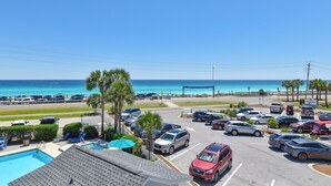 A parking lot with a pool and a view of the ocean. - Cozy 1 Bedroom🏝️ Gulf Views🌊Summerspell 309 (Miramar Beach)