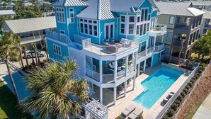 Une grande maison à plusieurs étages, dotée d’une piscine, de nombreux balcons et offrant une vue sur les environs.