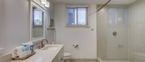 Une salle de bain moderne équipée d’une douche, de toilettes et d’un lavabo.