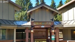 A building with a sign reading "EDELWEISS" at the entrance, wooden railings, and a staircase leading up to the entrance. - Summer special, stay before 9/8/26 get third night free ! (Government Camp)