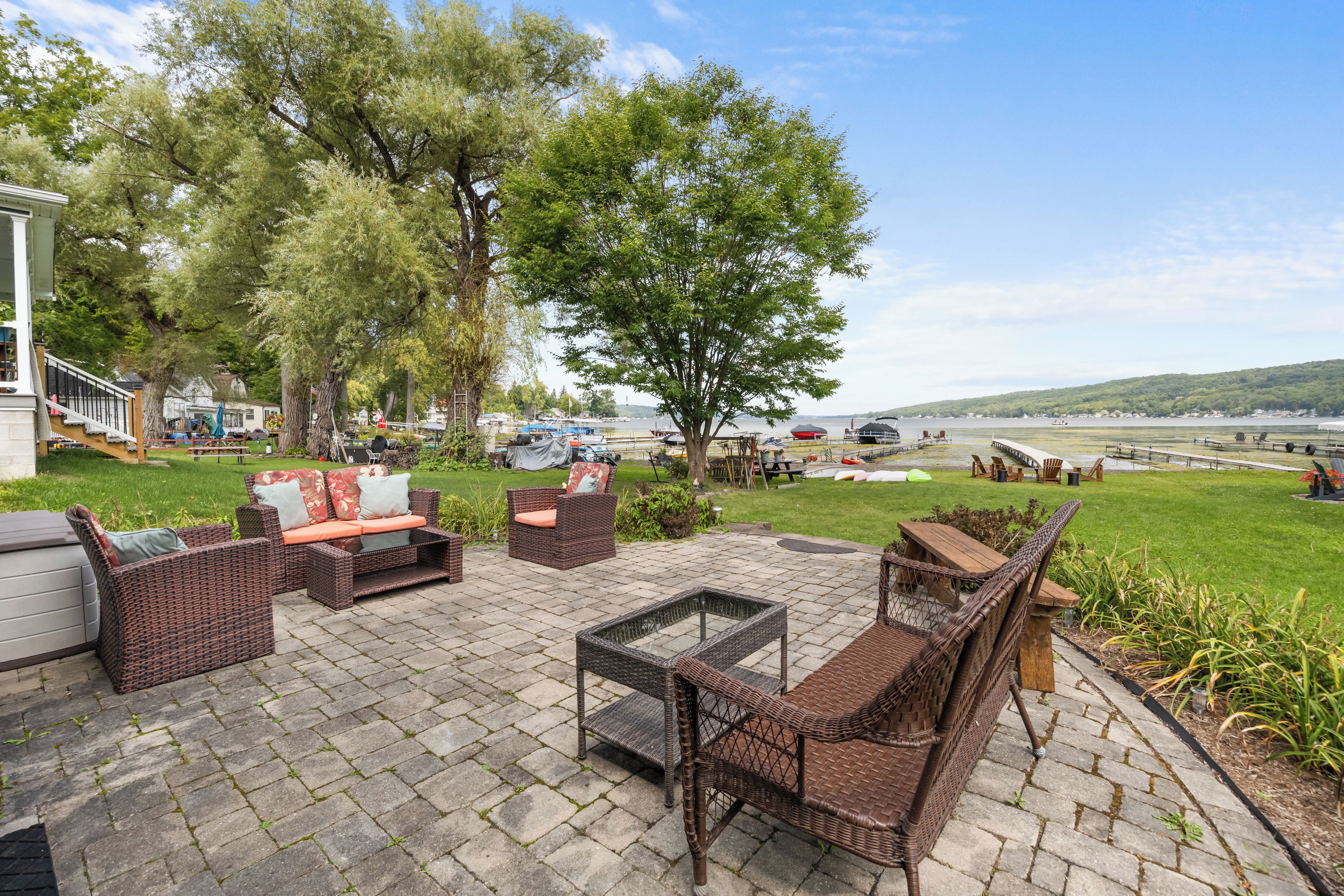 An outdoor patio with wicker furniture, a fire pit, and a view of the water.