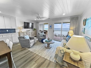 Enjoy a serene coastal view from the comfort of this well-appointed living space with a sofa, dining table, and large window.