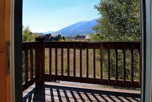 Eine Holzterrasse mit Blick auf eine gebirgige Landschaft.