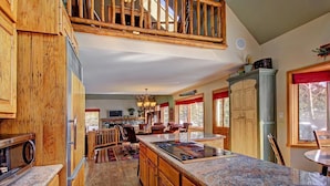 A spacious kitchen with a large island, wooden cabinetry, and a high ceiling with a balcony. - Free SkyCard Activities - Private Hot Tub, Ideal for Families - Gold King Lodge (Breckenridge)