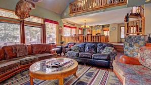 A cozy living room with leather sofas, a glass coffee table, and a stone fireplace. - Free SkyCard Activities - Private Hot Tub, Ideal for Families - Gold King Lodge (Breckenridge)