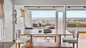 Un espace repas avec vue sur un aéroport, une grande fenêtre et une table entourée de chaises.