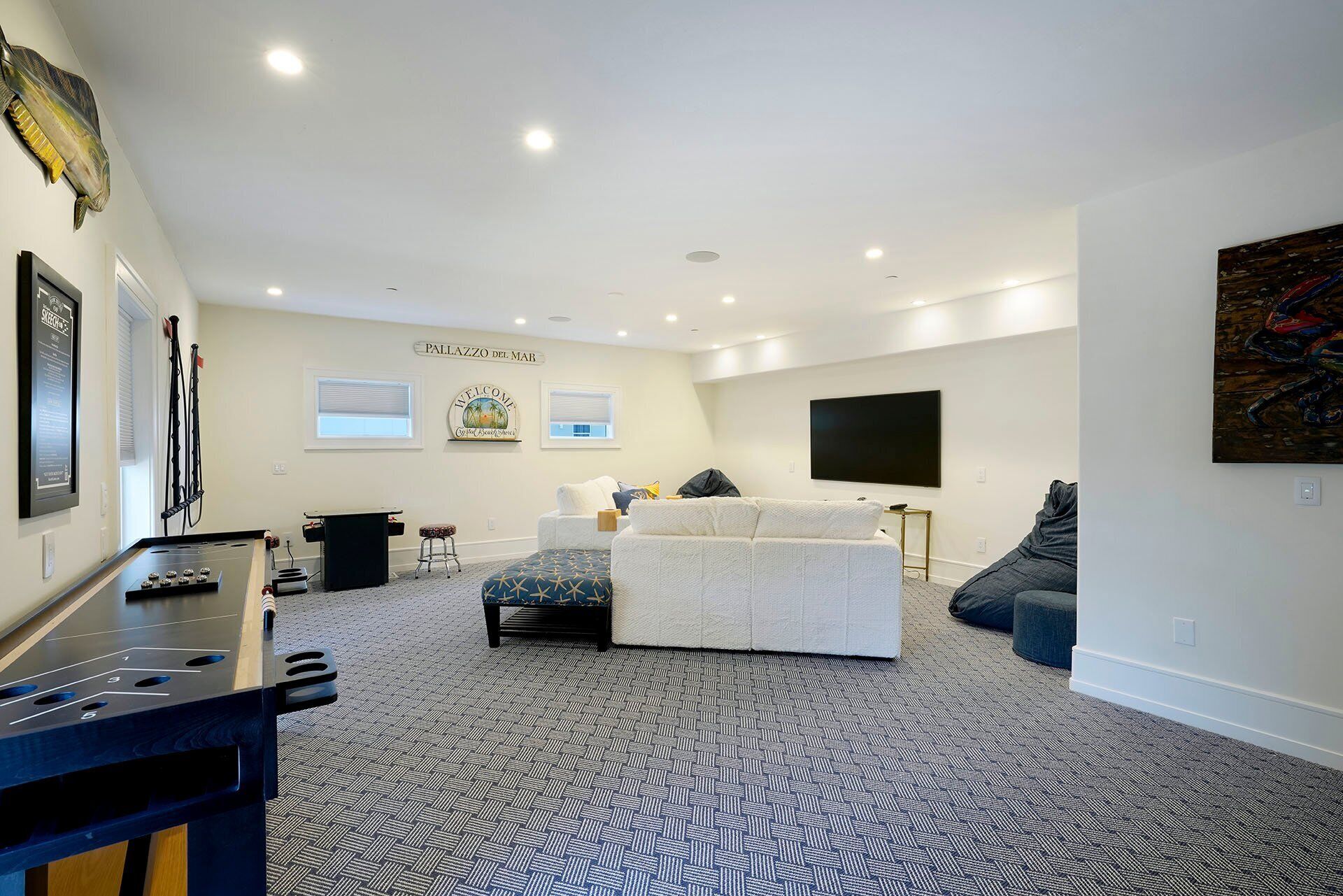 A spacious living room with a large bed, a flat-screen TV, and a billiards table.