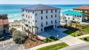 A multi-story hotel with a flat roof, located near a beach with clear blue waters. - Luna Sol - Beachfront Duplex with Private Pool Area & Beach Access (Destin)