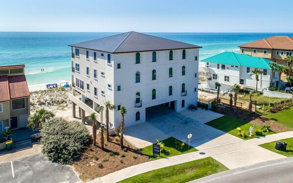A multi-story hotel with a flat roof, located near a beach with clear blue waters. - Luna Sol - Beachfront Duplex with Private Pool Area & Beach Access (Destin)