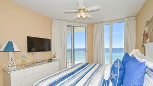 A bedroom with a bed, a TV, a dresser, and a view of the ocean. - Fresh, fun, & bright beachfront condo w/private balcony! (Destin)