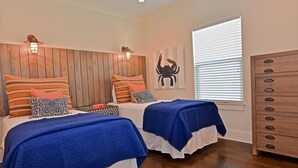 Un dormitorio con dos camas, cabecero de madera y cómoda.