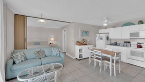 A compact living space with a kitchenette, a dining area, and a sofa with patterned cushions. - Beachfront Condo Offers Fun and Sun At Bargain Price! PET FRIENDLY! (Fort Myers Beach)