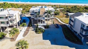 A modern multi-story hotel with balconies, a swimming pool, and a view of the beach and ocean. - Beachfront Bliss at Shell Island Beach Club 5D (Sanibel Island)