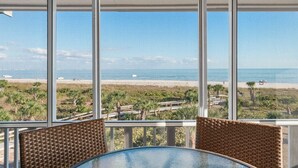 A beach view from a covered patio with wicker furniture. - Beachfront Bliss at Shell Island Beach Club 5D (Sanibel Island)