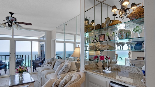 Un salón espacioso con balcón, una vitrina de cristal con adornos y una cocina moderna con lavavajillas integrado.