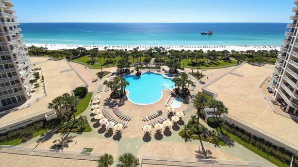 Een resort met een centraal gelegen zwembad, toegang tot het strand en uitzicht op de oceaan.