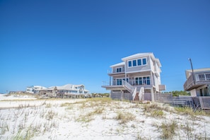 A beachfront property with multiple houses, including a prominent two-story building with a balcony.