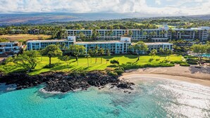 A resort with multiple buildings, a beach, and clear turquoise waters. - Best of Wai'ula'ula - Beautiful Decor, Ocean View, Resort Access! (Kamuela)