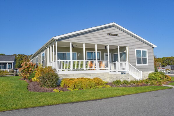 A single-story house with a covered porch, a front entrance, and a small front yard with landscaping.