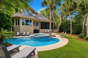 Il s’agit d’une propriété résidentielle dotée d’une piscine, de chaises longues et d’un patio couvert.