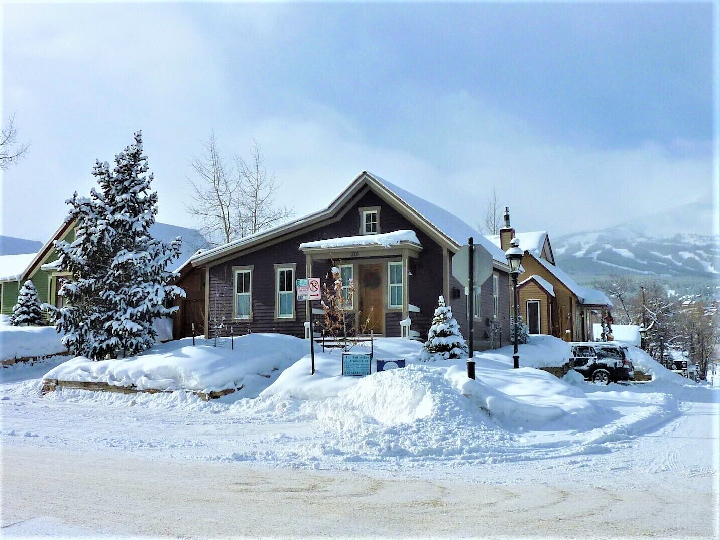 A two-story house with a snow-covered roof and a garage.