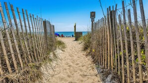 A sandy beach path with wooden fences and a clear blue sky. - Beautiful ocean front townhome in the heart of WB! (Wrightsville Beach)