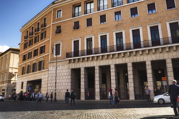 A multi-story building with a classical architectural style, featuring a central entrance with columns, large windows, and balconies. - Navona Living Rome (Rome)