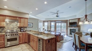 A spacious kitchen with a large island, built-in appliances, and a dining area with a fireplace.