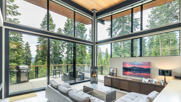 Una sala de estar moderna con un sofá grande, una chimenea y un televisor.