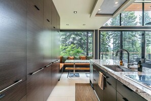 Una cocina moderna con un ventanal grande, un banco empotrado y vistas al exterior.