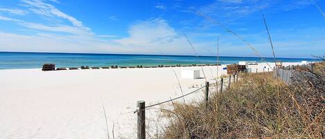 A beach with a sandy shore, wooden structures, and a clear blue sky.