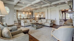 A spacious living room with a high ceiling, a dining area, and a kitchen.