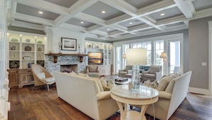 A spacious living room with a fireplace, built-in shelves, and a large window.