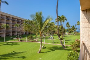 Un hotel con un campo da golf, palme e un cielo azzurro limpido.