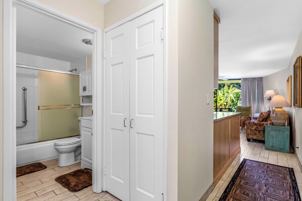 A modern bathroom with a shower, toilet, and white cabinets.