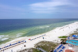 A beach with a pool, sun loungers, and a lifeguard tower. - LARGE 3 BEDROOM!! PLENTY OF ROOM & GREAT VIEWS! (Panama City Beach)
