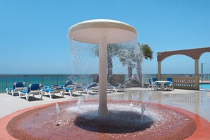 Relax by the serene water feature surrounded by a circular patio, lounge chairs, and tables.