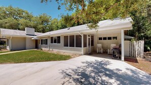 A single-story house with a covered patio area, a front door, and a small front yard. - Bradfield 4 bedrooms, 2.5 bathrooms (Jekyll Island)