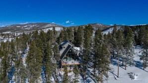 A cabin surrounded by snow-covered trees and mountains. - Breck A-Frame Ski + Golf Retreat | Hot Tub + Sauna (Breckenridge)
