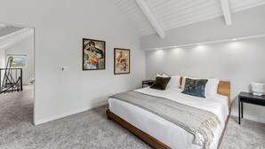 A bedroom with a large bed, a ceiling fan, and two wall-mounted paintings. - Breck A-Frame Ski + Golf Retreat | Hot Tub + Sauna (Breckenridge)