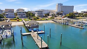A marina with docks, a covered seating area, and a hotel in the background. - Conley  A Sound Front Townhome with Boat Slip! (Wrightsville Beach)
