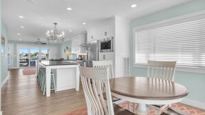 A modern kitchen with white cabinetry, stainless steel appliances, and a central island. - Conley  A Sound Front Townhome with Boat Slip! (Wrightsville Beach)