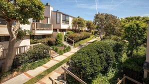 A residential area with multi-story buildings, a pathway, and lush greenery.