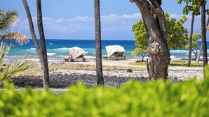A beach with covered seating areas and a view of the ocean. - 1st Floor Mauna Lani Terrace Condo - Private Beach Access! (Kamuela)