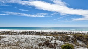 Une plage avec un rivage sablonneux et un ciel bleu dégagé.