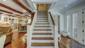 A staircase with wooden steps and white railings, leading to an upper floor. - Premium DOG FRIENDLY 4th Row Ocean Sea Pines Home with a Private Pool & Spa (Hilton Head Island)