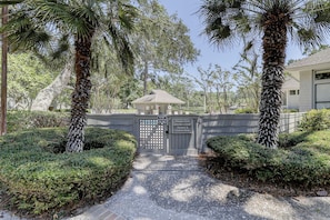 A gated entrance to a private pool area with a sign indicating it is for owners and guests only.